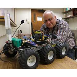 Purdue University School of Electrical and Computer Engineering associate professor Jeffrey Mark Siskind with the language-learning robot Darth Vader.